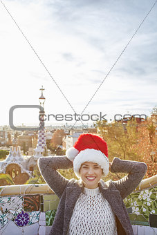 traveller woman in Santa hat at Guell Park relaxing on bench