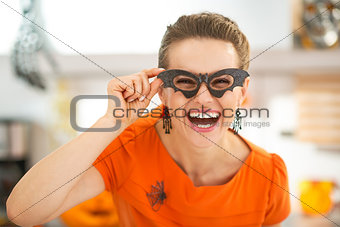 woman in party bat glasses in the Halloween decorated kitchen