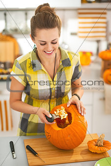 happy woman prepare big orange pumpkin for Halloween party