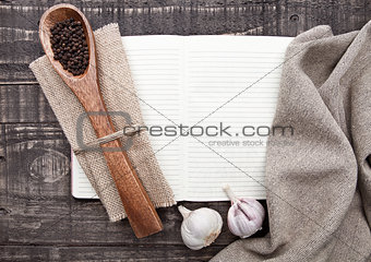 Notebook with pepper on spoon and kitchen towel