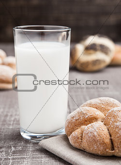 Glass of milk with bread roll for breakfast 