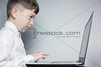 School child looking at computer over gray background