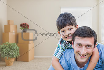 Father and Son in Room with Packed Moving Boxes and Potted Plant