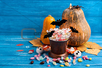Halloween composition with pumpkins, candy bucket, paper bats, r
