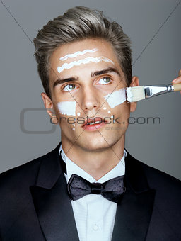 Fashion man with cosmetic cream treatment on his face.