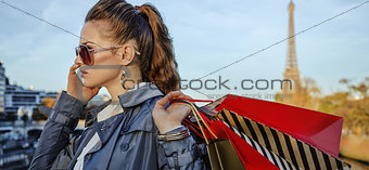 elegant woman with shopping bags speaking on mobile phone, Paris