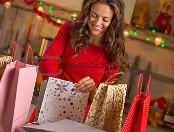 Smiling young woman with shopping bags in christmas decorated ki