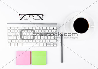 White keyboard with glasses and sticky note papers