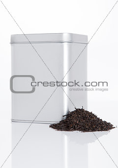 Black tea steel jar with loose tea next to it