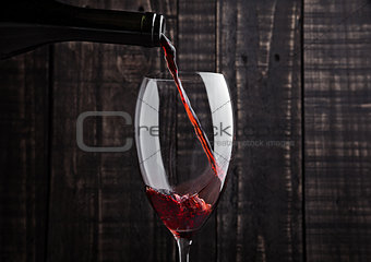 Pouring red wine into the glass from bottle 