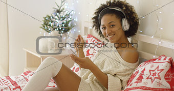 Cute young woman enjoying her music at Xmas