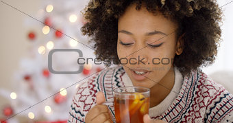 Young woman sipping a cup of hot lemon tea