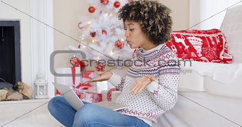 Cute young woman having a video chat at Christmas