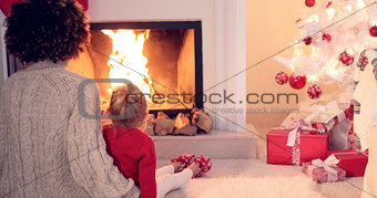 Mother and child warm up by the fireplace