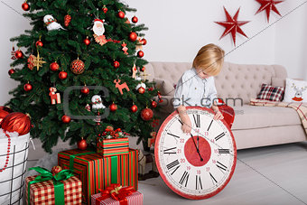 Boy with a big clock in Christmas tree