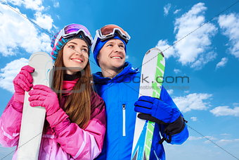 Smiling couple with skis