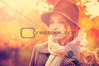 Fashion Woman in Hat on Orange Autumn Background