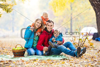 Happy young family with two boys in forest