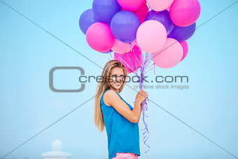 Beautiful young woman with a bunch of balloons