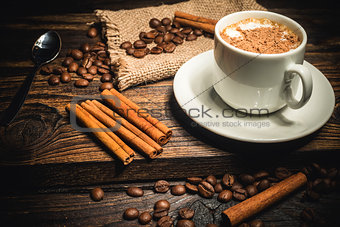 cup of coffee and ingredients on a wooden background