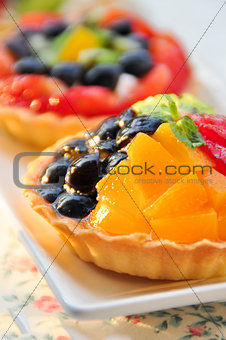 Two fruit tart on white dish, close up