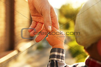  parent holds the hand of a small child