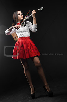 Pretty woman playing the violin on a black background