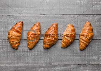 Fresh crispy croissant for breakfast on wood
