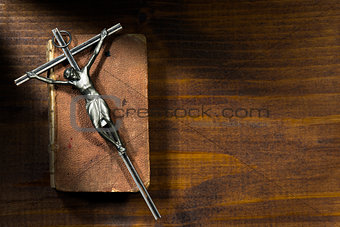 Silver Crucifix and Holy Bible on Wooden Background