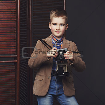 Handsome young boy with retro camera