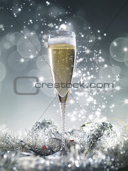 One champagne glass and silver decoration on a silver shiny glit