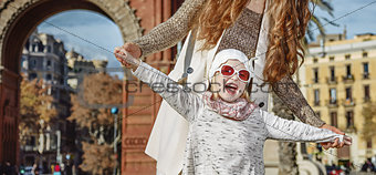 cheerful modern mother and child in Barcelona, Spain