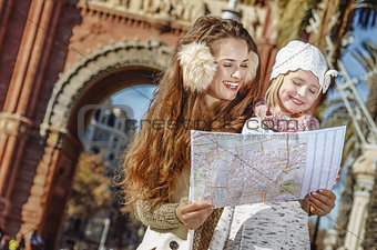 happy mother and daughter in Barcelona, Spain looking at map
