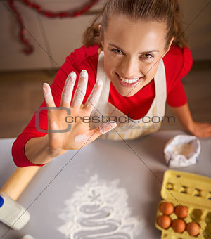 Young housewife showing hand smeared in flour