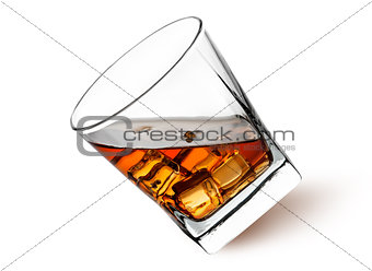 Whiskey with ice in a tilted glass
