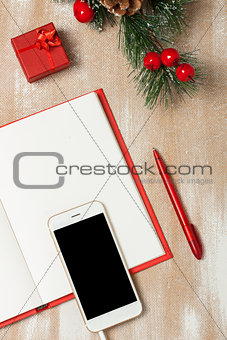 Christmas composition with notebook, gift and smartphone