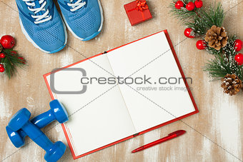 Christmas sport composition with  shoes, dumbbells and note