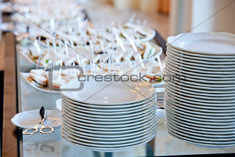 a stack of white plates on banquet table