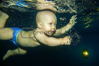Little boy learning to swim underwater in   a swimming pool