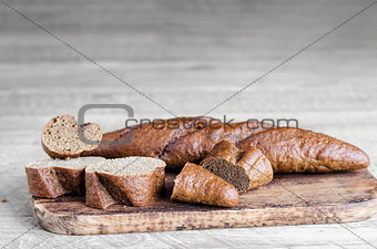 Whole and sliced bread on a gray wooden background