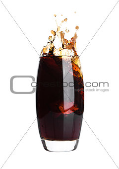 Glass of cola with splash and ice cubes on white