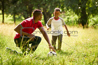 Sport Practice With Father Teaching Son How To Play Soccer