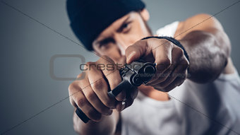 Handsome criminal holding a gun