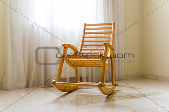 Wooden rocking chair near the window in room