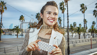 smiling trendy fashion-monger in Barcelona, Spain writing sms