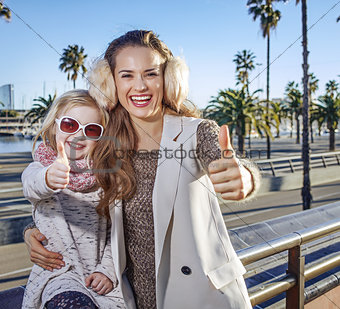 mother and child tourists in Barcelona, Spain showing thumbs up