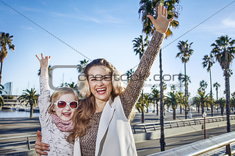 smiling mother and child tourists in Barcelona, Spain rejoicing