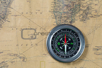 the Black compass on old vintage map, south atlantic ocean, macro background