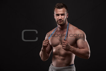 Muscular man with measurement tape