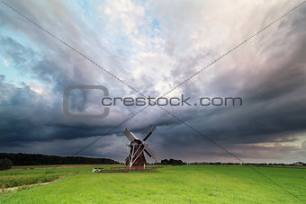 dark stormy clouds over windmill